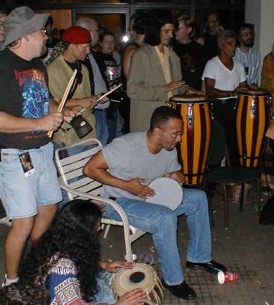 Jason Carter and Richard Biggs playing drums on the pool deck.